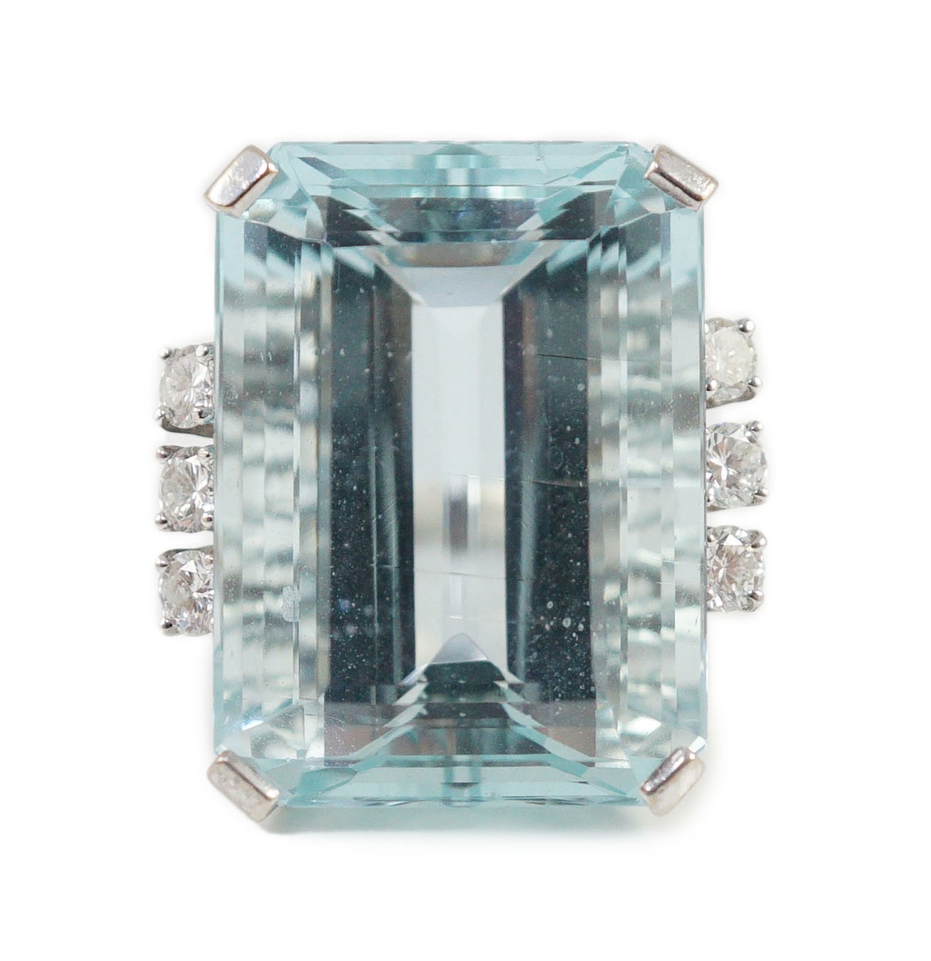 A large modern 14k white gold and emerald cut aquamarine set dress ring, flanked by six round cut diamonds